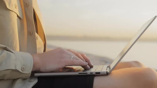 Digital Nomad of the Millennial Generation is Working on a Laptop on the Beach