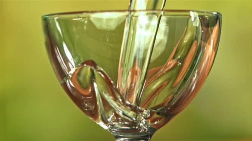 Clear Liquid Being Poured into Elegant Glass