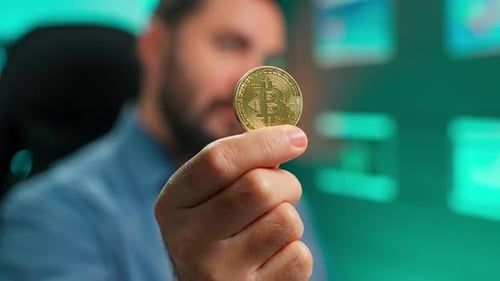 Man Presents Golden Bitcoin Cryptocurrency Coin in Studio