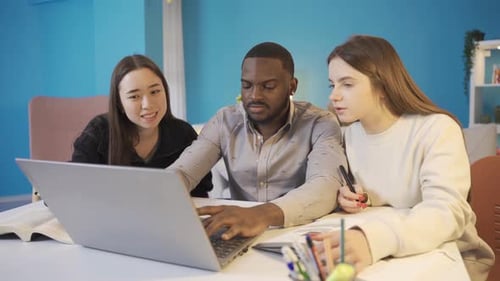 Young Adults Studying Together on Laptop