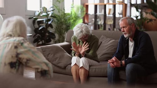 Married couple in therapy with a professional about marital problems, senior people at the psycholog
