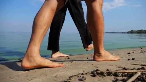 Bare Feet of Couple Stepping Together Along Sand Beach at Coastline Male and Female Legs of Pair