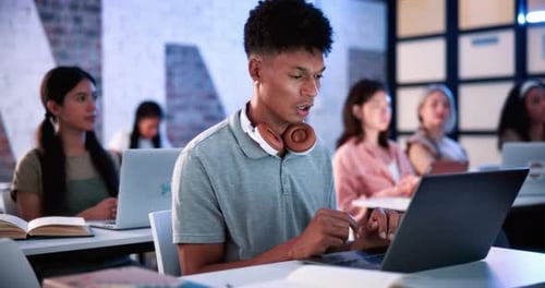 Man, laptop and tired in classroom with yawn at university with notes, review