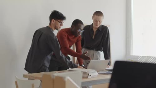 Three Young Adults Collaborating in Modern Office