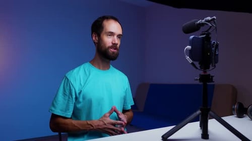 A Young Blogger Records a Video with Himself on His Phone in His Studio