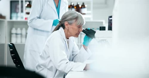 Scientists Use Microscope and Tablet in Laboratory