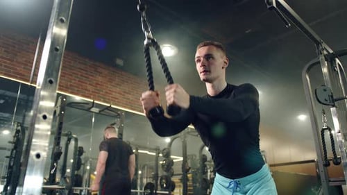 Young Handsome Man Doing Exercises on Vertical Row Machine Hands Back Workout