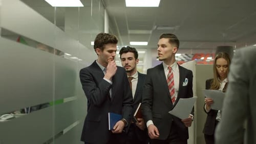 Kollegen besprechen die Arbeit, während sie durch den Bürokorridor gehen