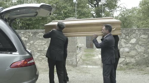 Pallbearers in Hearse arriving with coffin at graveyard
