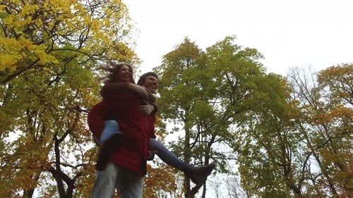 Happy young couple having fun in autumn park romance in the fall season