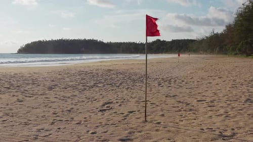 Empty Phuket beach with red flags