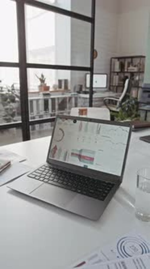 Vertical of Wireless Laptop with Business Statistics on Office Desk