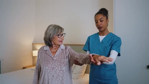 Woman Doing Exercises With Physical Therapist in Home