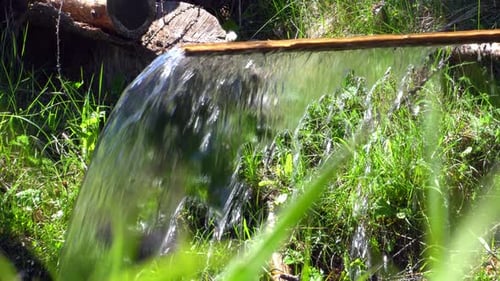 Water flowing off a wooden plank on a hot day. - close up