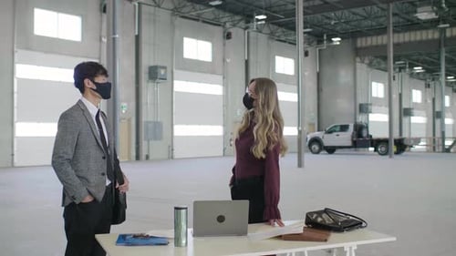 Realtor and investor discussing new commercial real estate project in empty warehouse