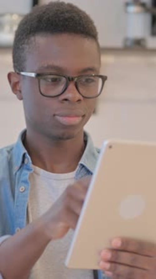 Teen Boy With Glasses Using Digital Tablet