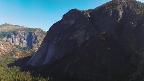 Huge mountains with pine trees on tops and at the foot. Yosemite National Park rocks