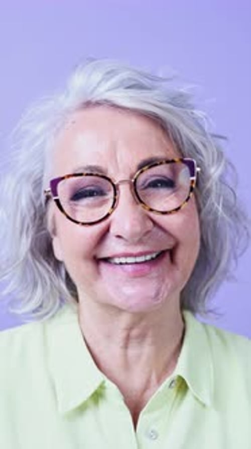 Femme âgée joyeuse avec des lunettes souriant brillamment