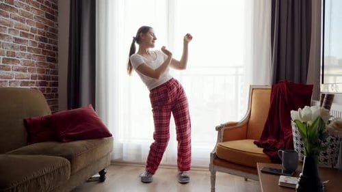 Woman Dancing Joyfully in Living Room at Home