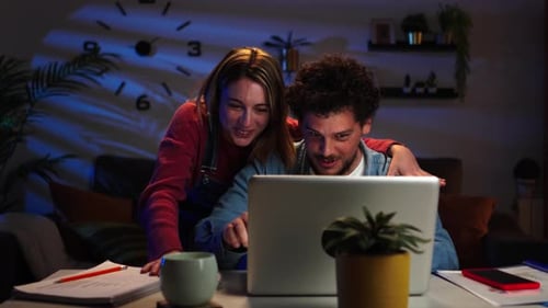 Young Adult Married Couple Doing a Countdown to Buy a Real Estate Property Using a Laptop They