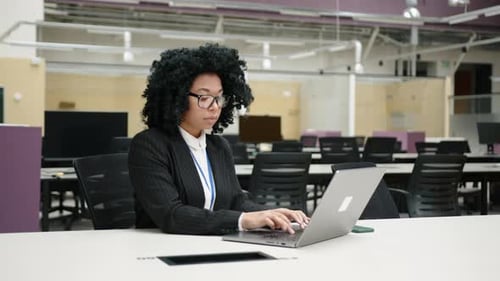 Closeup of African American Woman in Glasses and Formal Suit Working in Office