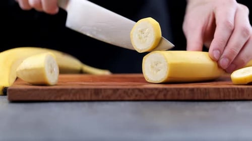 Slicing Ripe Yellow Banana on Cutting Board