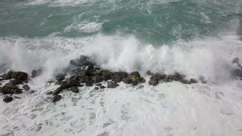 Waves Crashing on Rocky Shoreline Aerial View