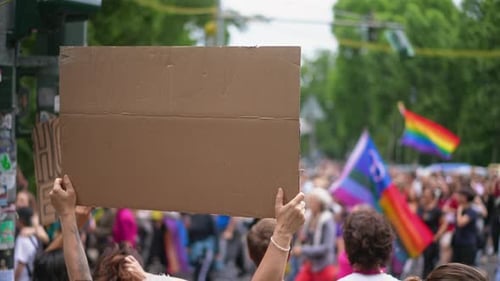 Crowd Marches Holding Blank Sign and Rainbow Flags
