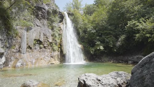 Cascada entre rocas y árboles verdes
