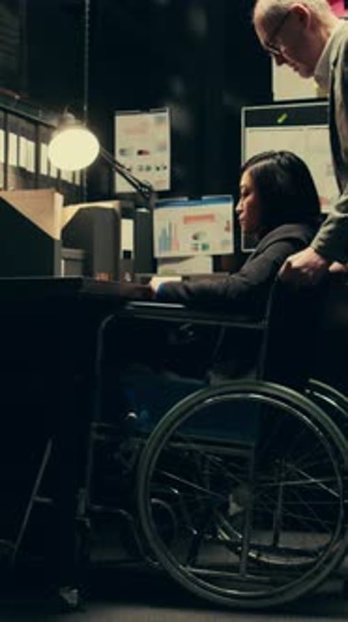 Woman Typing on Laptop in Wheelchair at Office