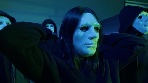 Une équipe de cybercriminels avec des masques blancs anonymes au bureau la nuit