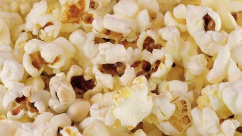 Rotating popcorn grains. Popcorn background. Macro and close-up.