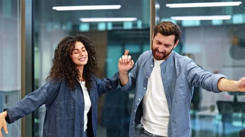 Business Colleagues Celebrate Success with Energetic Dance in Modern Office