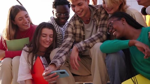 Happy Young Adults Looking at Phone Together