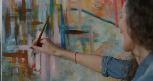 Woman Painting Abstract Art on Canvas in Studio