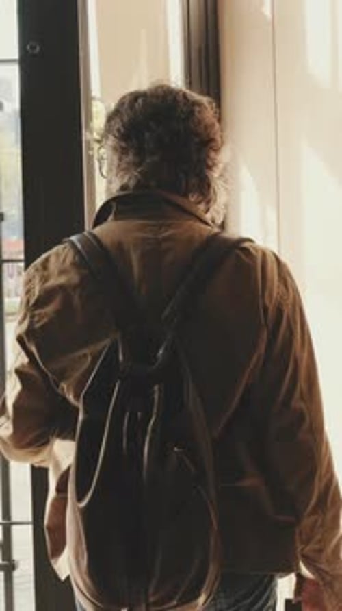 Homem de meia idade saindo de casa com bagagem