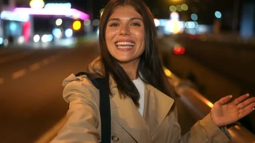 Influencer woman vlogging on a city bridge at night