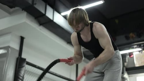 Man Doing Battle Rope Workout in Gym