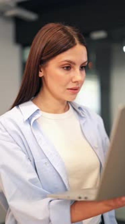 Focused Young Woman Engaged with Laptop at Work
