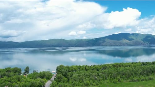 View on lake from driving car. Trees near Sevan lake In Armenia, Caucasus.