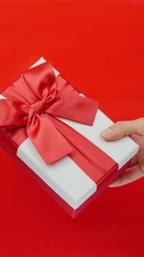 Birthday Present Being Placed on Red Surface