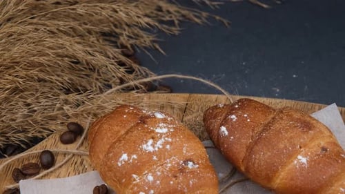 Fresh Croissants on Wooden Board with Coffee Beans