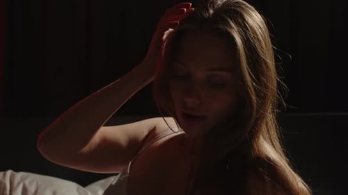 Beau portrait d'une jeune femme séduisante posant sensuellement au lit