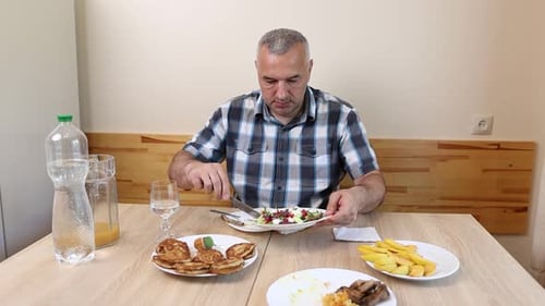 Adult Man Eating Meal with Pancakes and Salad