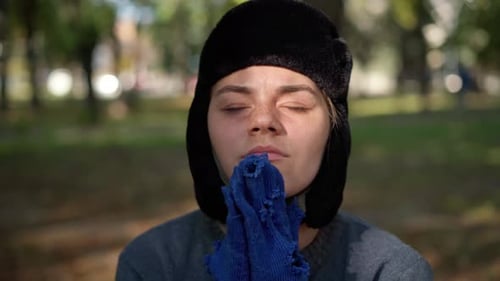 Young Woman Holding Worn Glove in Urban Setting