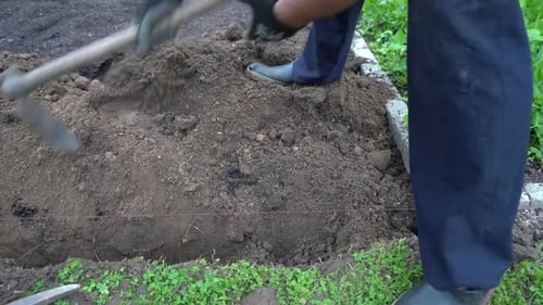 Gardener Digging Soil With Wood Handled Garden Hoe, Close Up Shot