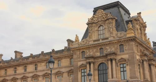 O Museu do Louvre em Paris com arquitetura intrincada sob um céu nublado