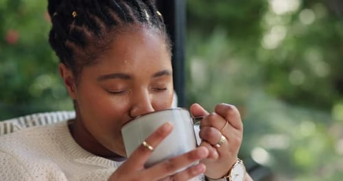 Woman Enjoys Hot Beverage, Smiling Calmly Indoors