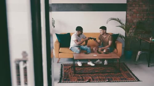 Cheers, coffee shop and men on a couch, friends and happiness with celebration, relax and peaceful