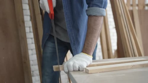 Carpenter is working at woodshop.